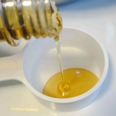 honey being poured into a small white bowl