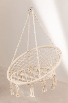 a white hanging hammock with tassels