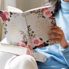 a woman sitting on a couch reading a book with flowers all over her face and the words, she loves you so much