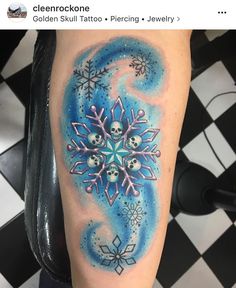 a snowflake tattoo on the arm with skulls and stars around it in blue