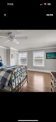 a bed room with a neatly made bed and a ceiling fan