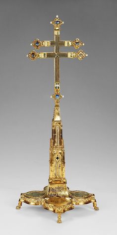 an ornate golden cross on top of a stand