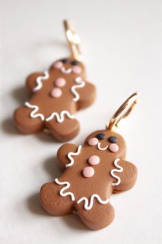 two brown and white ginger shaped cookies on gold earwires, one with pink polka dots