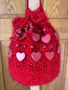 New, hand crafted by seller, this medium-large drawstring bag is perfect for everyday or special occasions and the right size for a cell phone and other items. Made of sparkly red acrylic yarn for the bag, the wooden hearts and beads are crocheted securely into the design. With 6" diameter base, it has a sturdy nylon cord for the strap and red wooden beads crocheted securely on the ends of the drawstring. Pouch is not lined so it will stretch to accommodate your items. Strap is 45" from one side of the pouch to the other providing a drop of approximately 22.5" from the shoulder or across the body. See photos for details and please ask if you have any questions. Yarn Crochet Bag As Gift, Crochet Yarn Bag Perfect As A Gift, Red Crochet Pouch Bag For Gift, Casual Red Crochet Bag With Adjustable Strap, Red Bohemian Crochet Bag, Red Crochet Pouch Bag, Handmade Red Crochet Satchel Bag, Red Bohemian Beaded Shoulder Bag, Luxury Red Beaded Bag