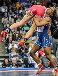 two wrestlers are wrestling in front of an audience