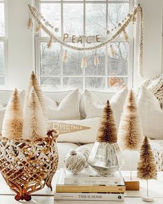 a living room filled with lots of white furniture and christmas trees on top of books