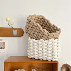 a white basket sitting on top of a wooden shelf