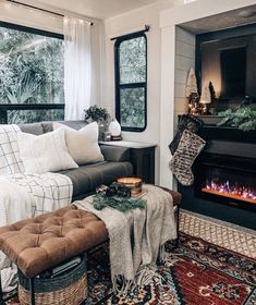 a living room filled with furniture and a fire place in front of a window on top of a rug