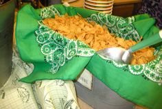 a bowl full of food sitting on top of a table next to some napkins