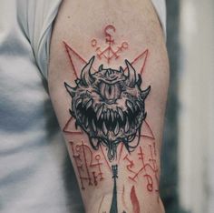 a man with a tattoo on his arm and an evil demon head in the middle