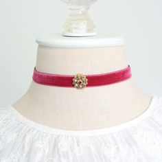 A beautiful accessory for the upcoming holiday celebrations! This eye-catching choker necklace is handmade with a soft velvet ribbon in a raspberry red hue. It features a vintage sparkling crystal amethyst jewel in a beautiful gold tone setting. A one-of-a-kind gift for a friend who loves unique jewelry! Also available with blue, lavender and black velvet ribbon. See last group photo showing coordinating necklaces... listed separately in the Rosy Posy Designs shop. * Size ~ Adjustable length 12 Adjustable Wedding Choker For Valentine's Day, Luxury Red Choker For Gift, Vintage Red Choker For Party, Vintage Choker For Valentine's Day, Red Ruby Choker Jewelry, Red Vintage Choker Jewelry, Elegant Ribbon Choker Necklace, Velvet Ribbon Necklace, Red Velvet Choker