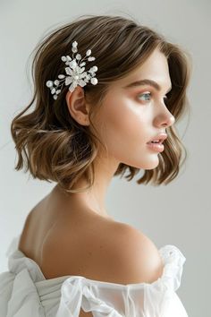 a woman wearing a white dress with a hair comb in the shape of a flower