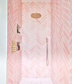 a bathroom with pink wallpaper and white flooring, including a shower head in the corner