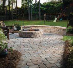 an outdoor fire pit surrounded by brick pavers