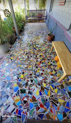 a bench sitting on top of a colorful floor covered in lots of different colored tiles