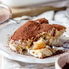 a piece of cake on a plate with a fork in it and some powdered sugar