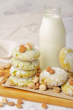 cookies and almonds on a cutting board next to a bottle of milk