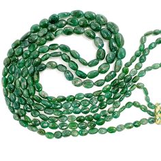 a long strand of green jade beads on a white background