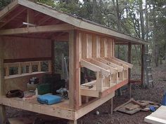 a small wooden structure in the woods with tools and supplies on it's sides