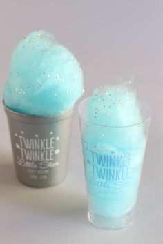 two cups filled with ice cream and one has blue icing on it, while the other is silver