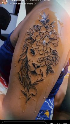 a woman's arm with a lion and flower tattoo on the left side of her body