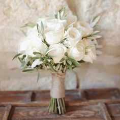 a bouquet of white flowers sitting on top of a table