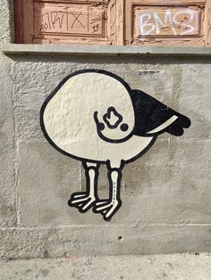 a sticker on the side of a building with a bird painted on it's face