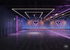 an empty room with purple lighting and white walls