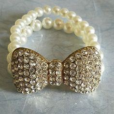 Never Used. Plastic Pearl. Gold Bow Tie Is Covered With Rhinestones. White Pearl Jewelry With Rhinestones, White Party Bracelets With Rhinestones, White Rhinestone Bracelets For Party, White Rhinestone Crystal Bracelet For Party, White Crystal Rhinestone Bracelet For Party, White Crystal Bracelet With Rhinestones For Party, Party White Crystal Bracelet With Rhinestones, Adjustable Sparkling White Bracelets, White Bling Bracelet