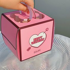 a pink box with a heart on it being held by someone