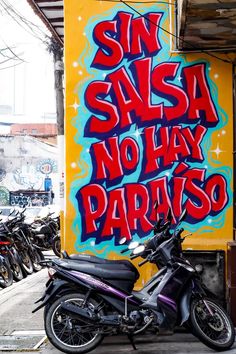 a motorcycle parked in front of a graffiti covered wall