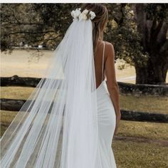 a woman in a wedding dress with a veil over her head