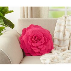 a pink flower sitting on top of a white couch