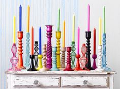 colorful candles are lined up on an old dresser