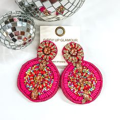 A small circle connected to a bigger circle and the bottom. These earrings have fuchsia and multicolored beaded design. There is also some gold stitched designs and champagne crystal beads throughout. Handmade Pink Beaded Earrings For Beach, Pink Beaded Drop Earrings For Festivals, Pink Large Beads Dangle Earrings, Pink Dangle Beaded Earrings With Large Beads, Pink Large Beaded Dangle Earrings, Handmade Pink Beaded Earrings For Party, Pink Bohemian Earrings For Vacation, Pink Beaded Earrings For The Beach, Pink Beaded Earrings For Beach