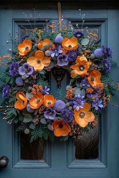 an orange and purple wreath on a blue door