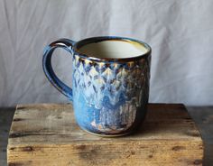 a blue and white mug sitting on top of a wooden table