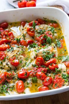 a casserole dish filled with fish and tomatoes