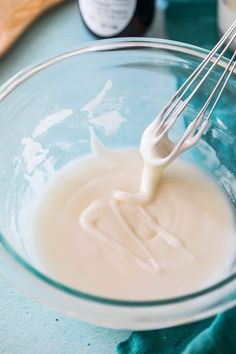 a whisk in a glass bowl filled with liquid