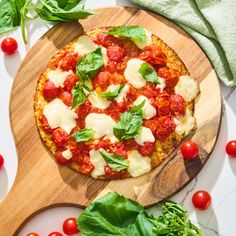 a pizza sitting on top of a cutting board covered in cheese and veggies