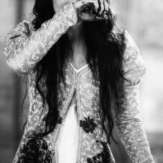 black and white photograph of a woman with long hair holding her hands to her mouth