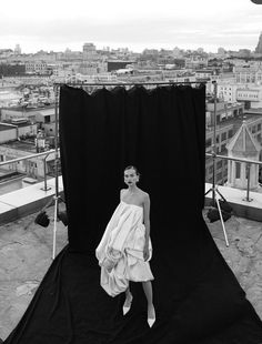 a black and white photo of a woman in a towel on top of a building