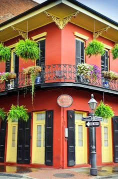 an orange building with potted plants on the balconies