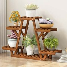 three tiered wooden plant stand with succulents and plants on it's sides