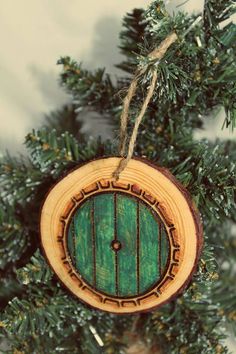 a wooden ornament hanging from a christmas tree with a green door on it