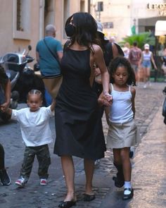 a woman and two children walking down the street