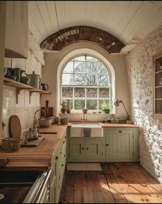 a kitchen with an arched window and wooden flooring in front of the counter top