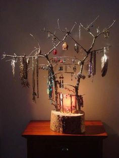 a wooden table topped with a tree filled with jewelry