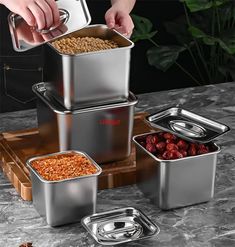 three stainless steel containers with food in them