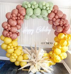 a birthday balloon arch with balloons in the shape of an oar and pineapple